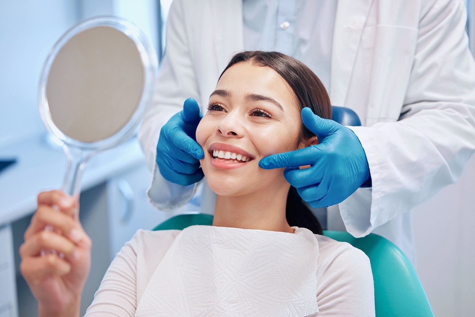 A woman examining her smile after a dental cleaning